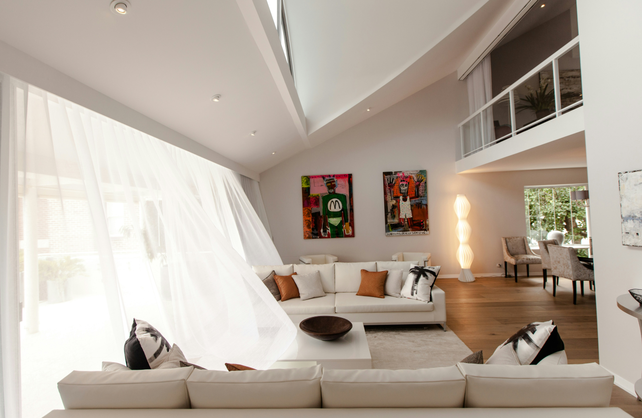 Light airy summer living room with linen curtains indoor plants and fan creating a cool calm space
